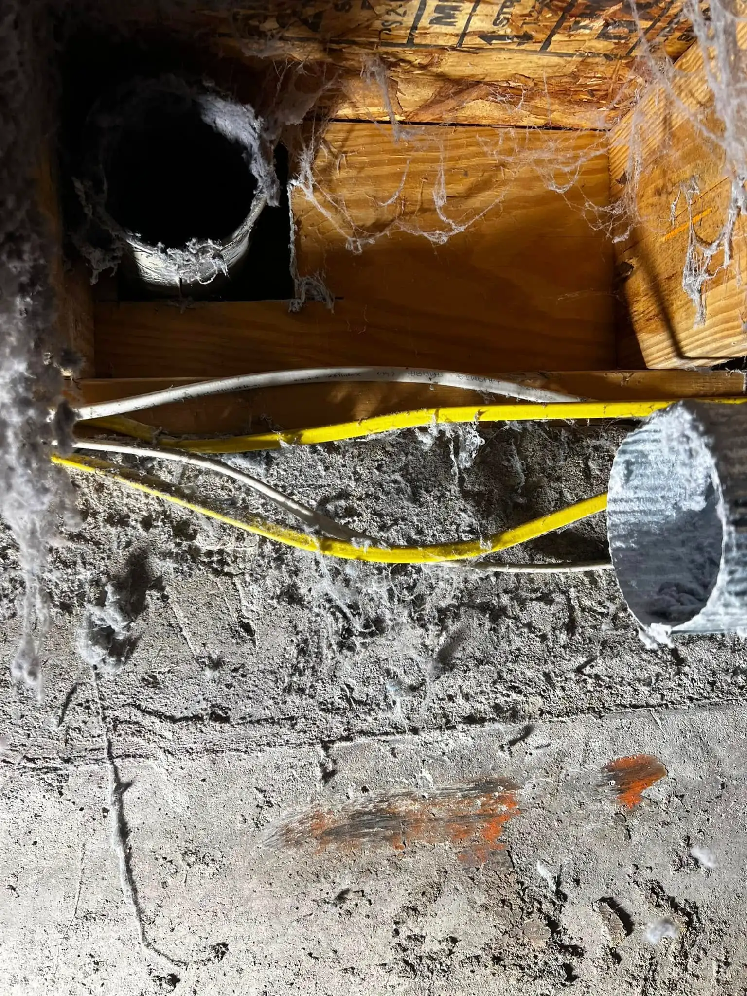 Lint-covered duct penetration and wiring found during a Vent Force safety inspection